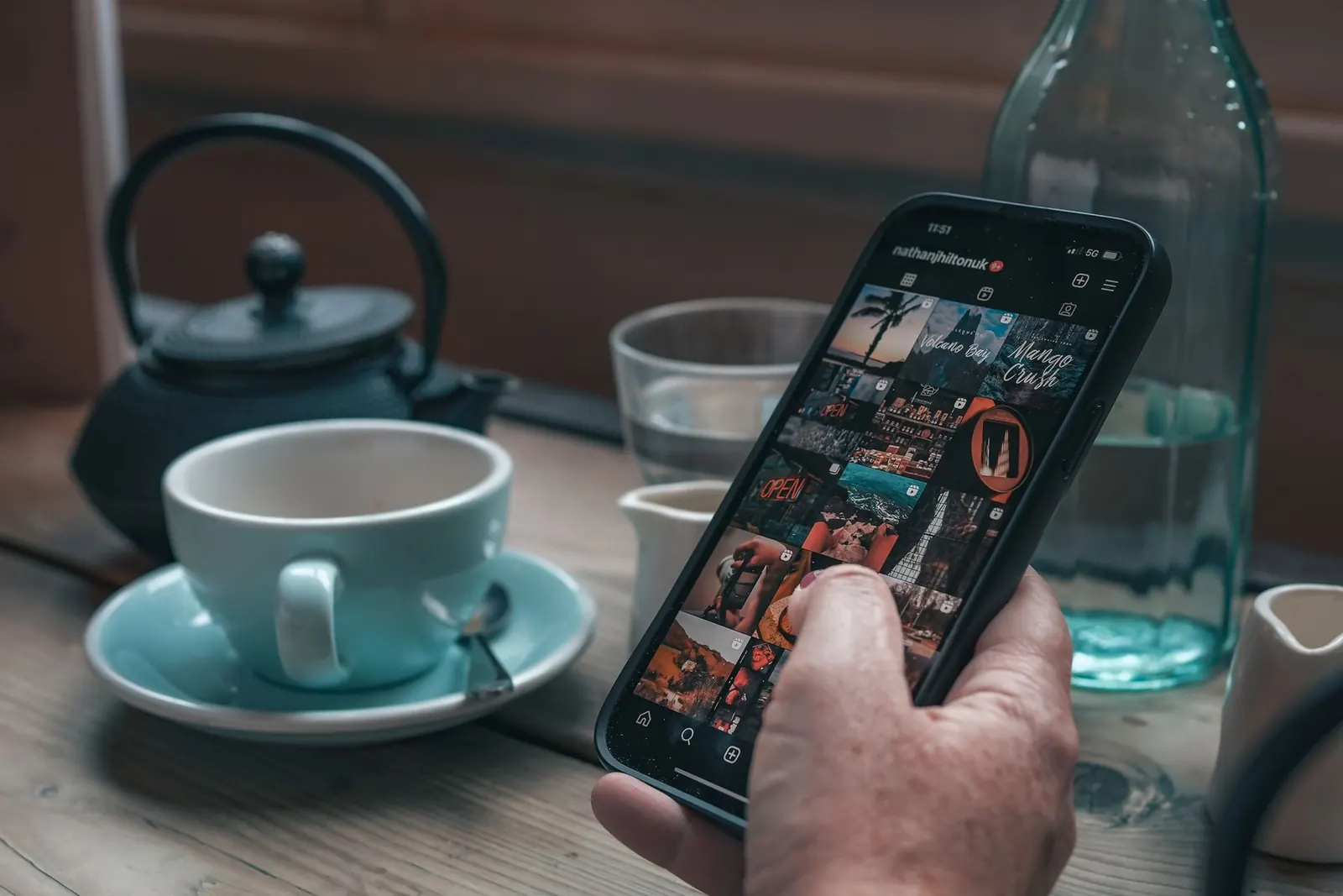 Smartphone mit Instagram-Feed neben einer Teetasse